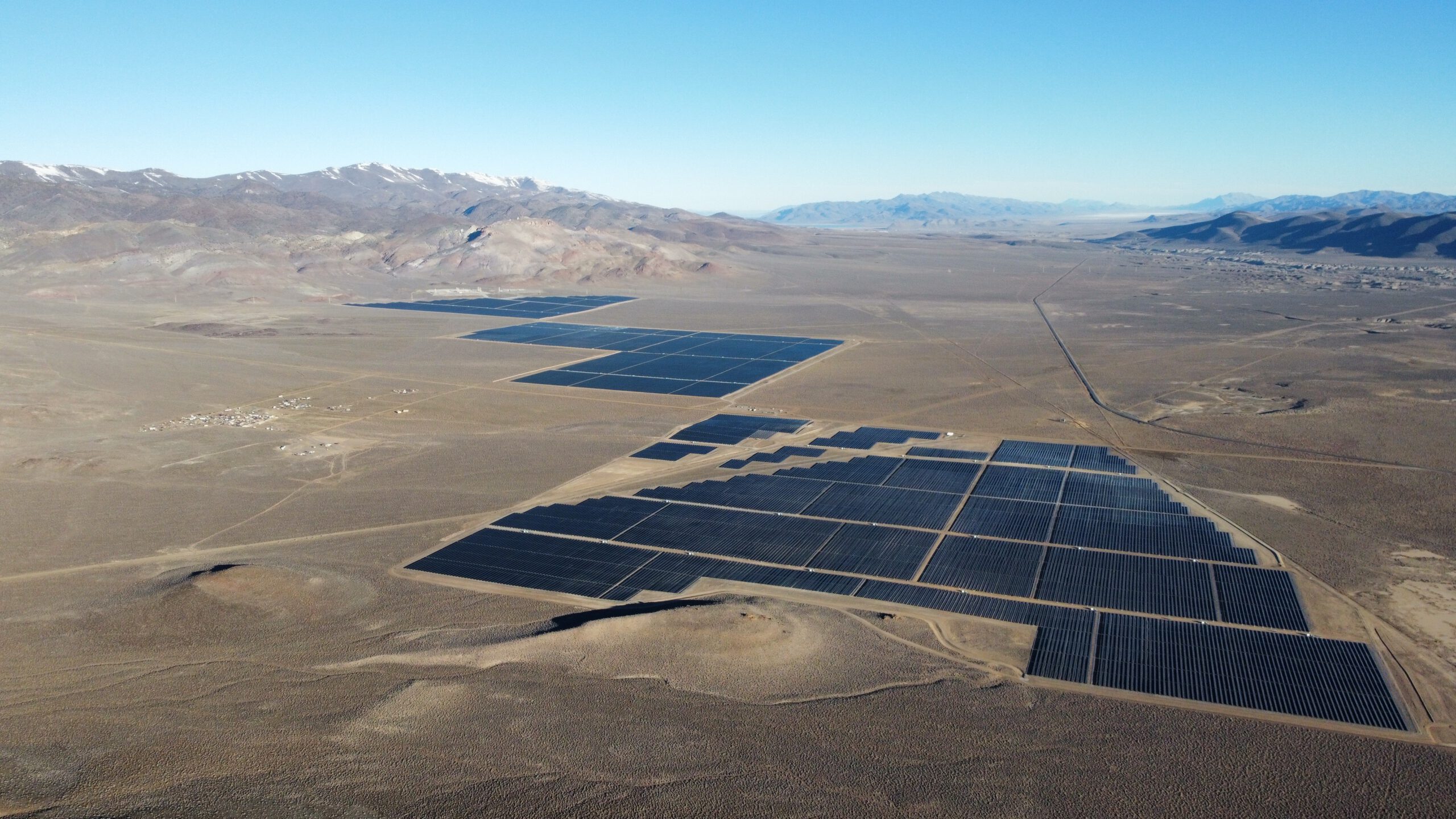 A mountainous desert landscape with solar grids