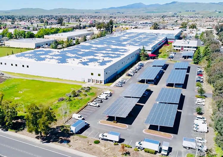 Solar panels covering a parking lot and large office building next to it