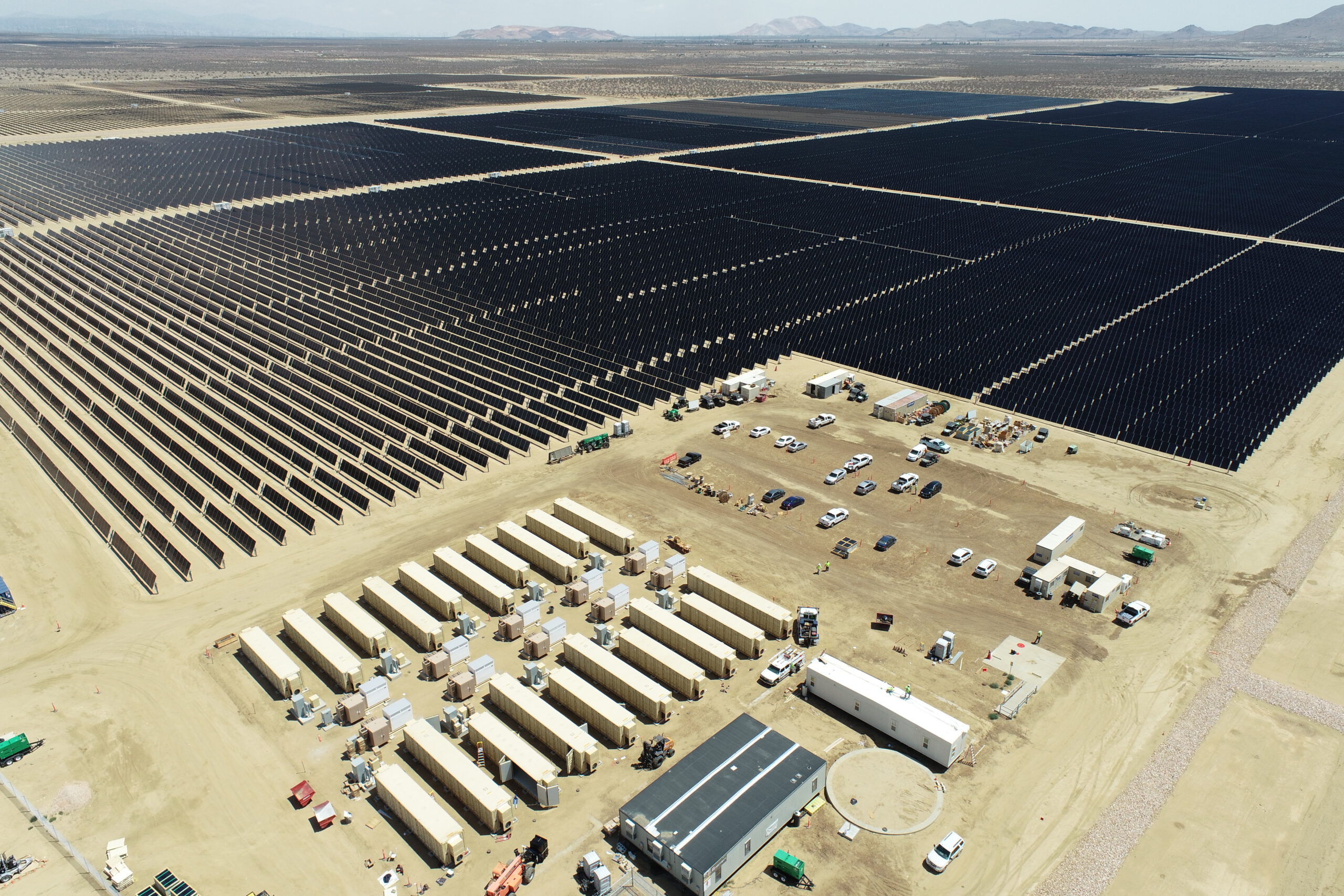 A bright desert landscape with solar panels and energy storage installation