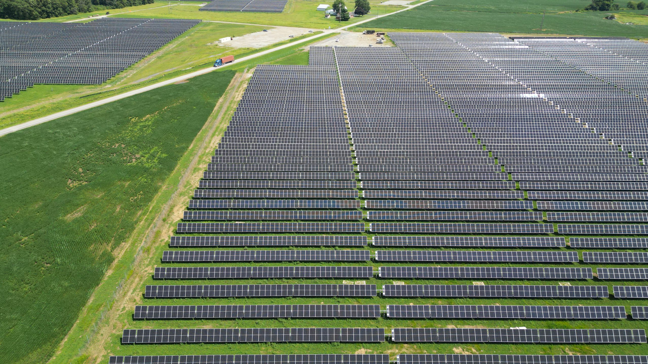 Thousands of solar panels arranged on a green landscape